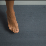 Nebia Quick-Dry Earth Mat dries within minutes when a women steps out from her shower